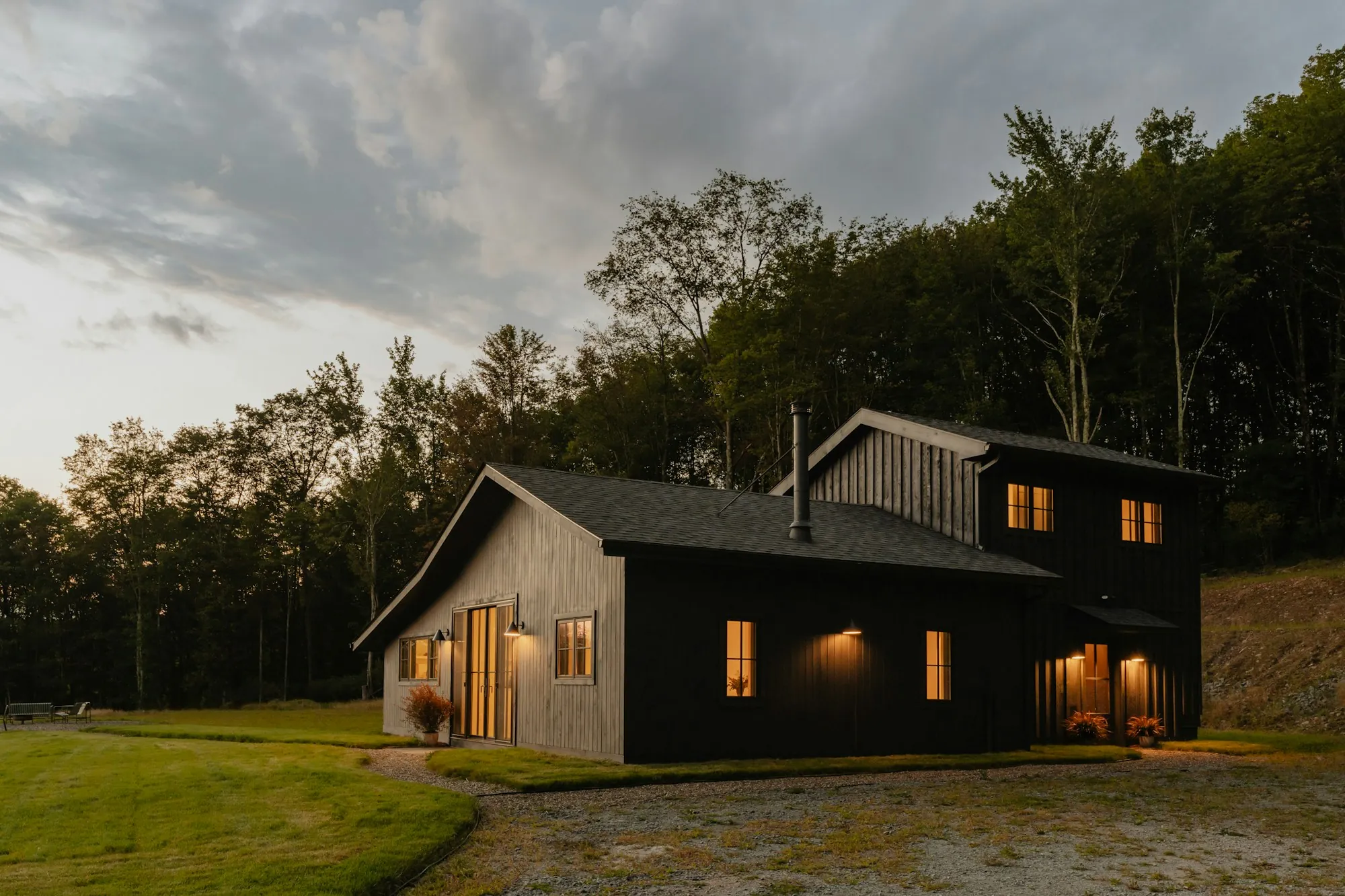 Dark wood house with warm lit windows at dusk