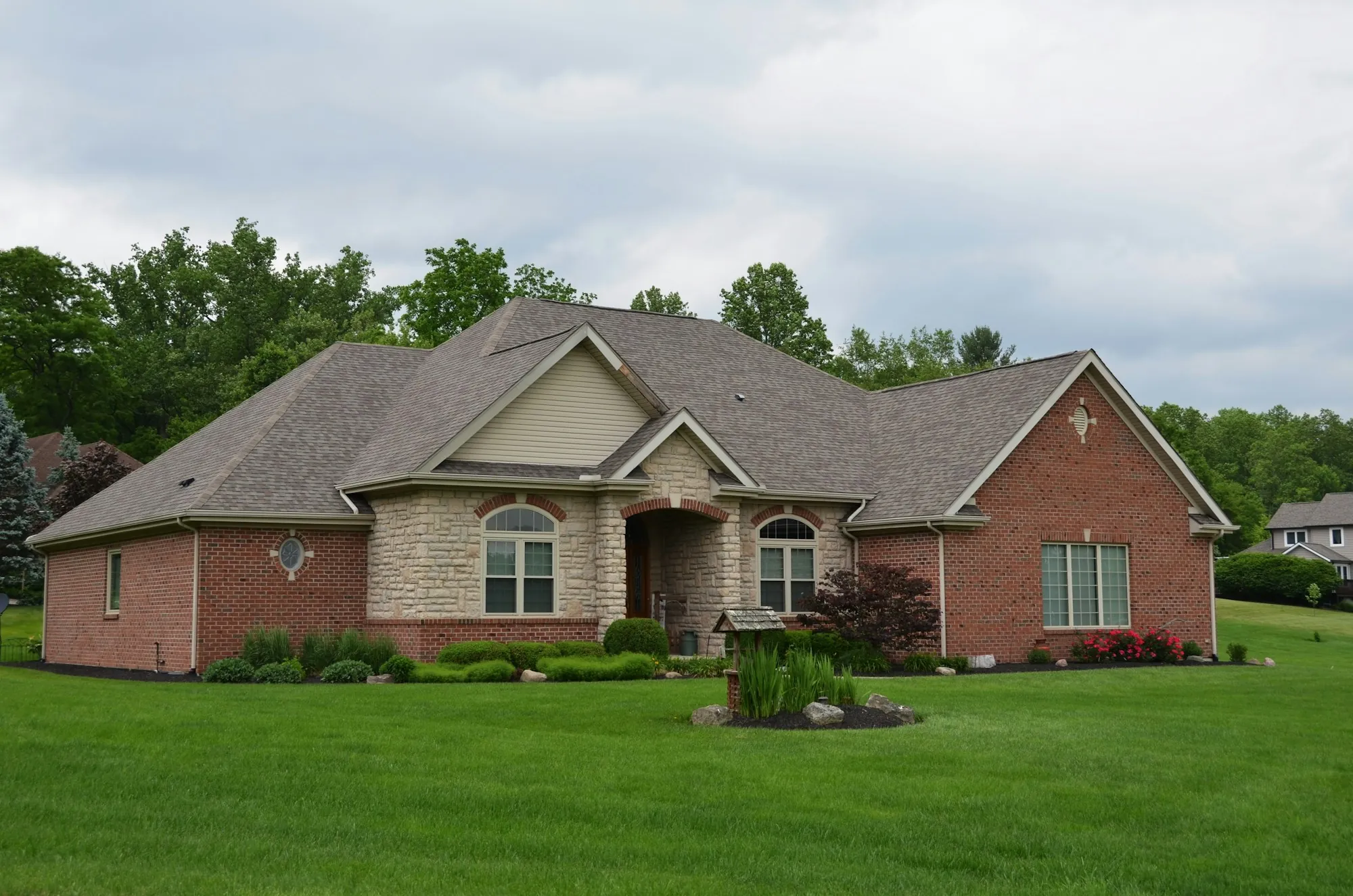 Brick and stone home with a landscaped front yard