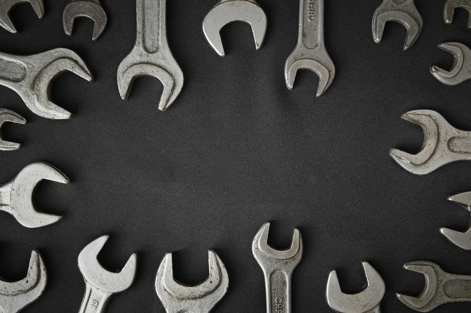 Set of open-end wrenches arranged on a dark surface